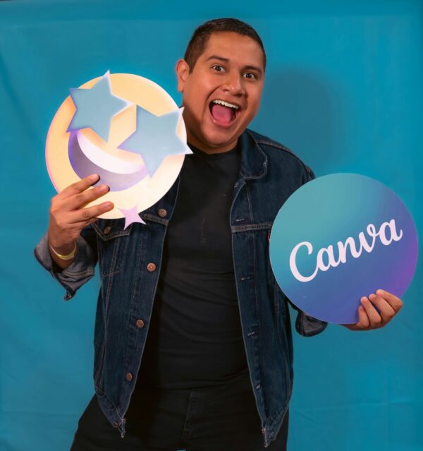 Happy person holding emoji and Canva signs against a teal background, showcasing excitement.